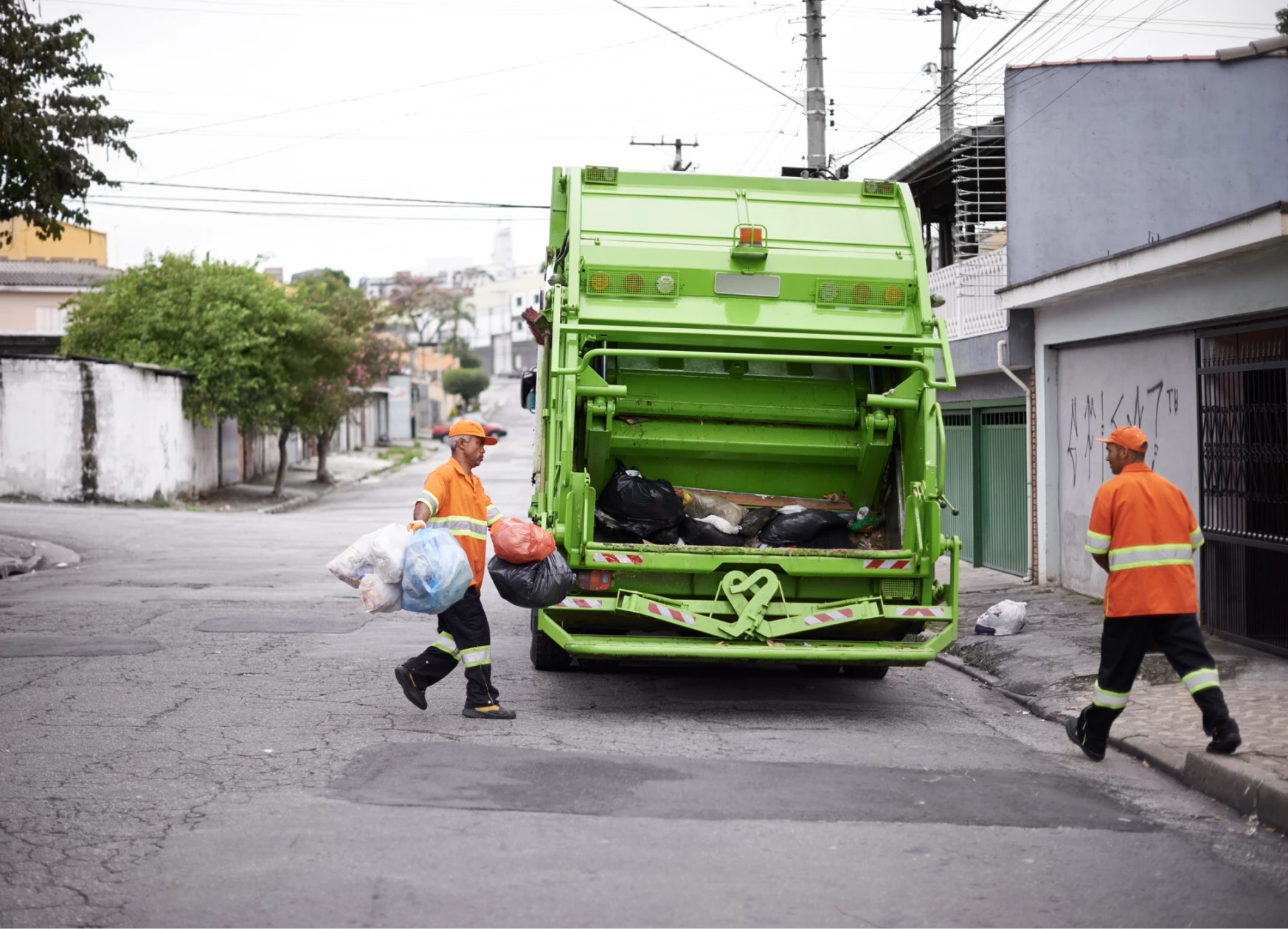 Sanitation workers loading trash into truck